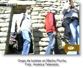 Turistas visitando Machu Picchu Imagen de turistas caminando por ruinas incas en Cusco.