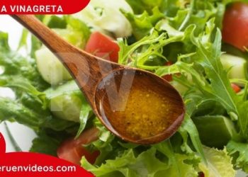 Imagen de una cuchara con salsa vinagreta que se echa sobre un plato con ensalada