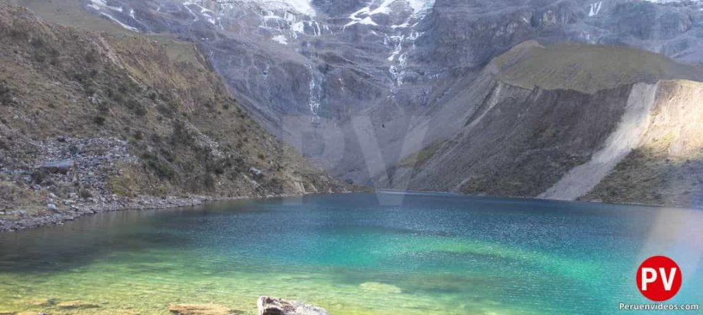 Brillante colores turquesa de la Laguna Humantay con el nevado detrás en el Cusco
